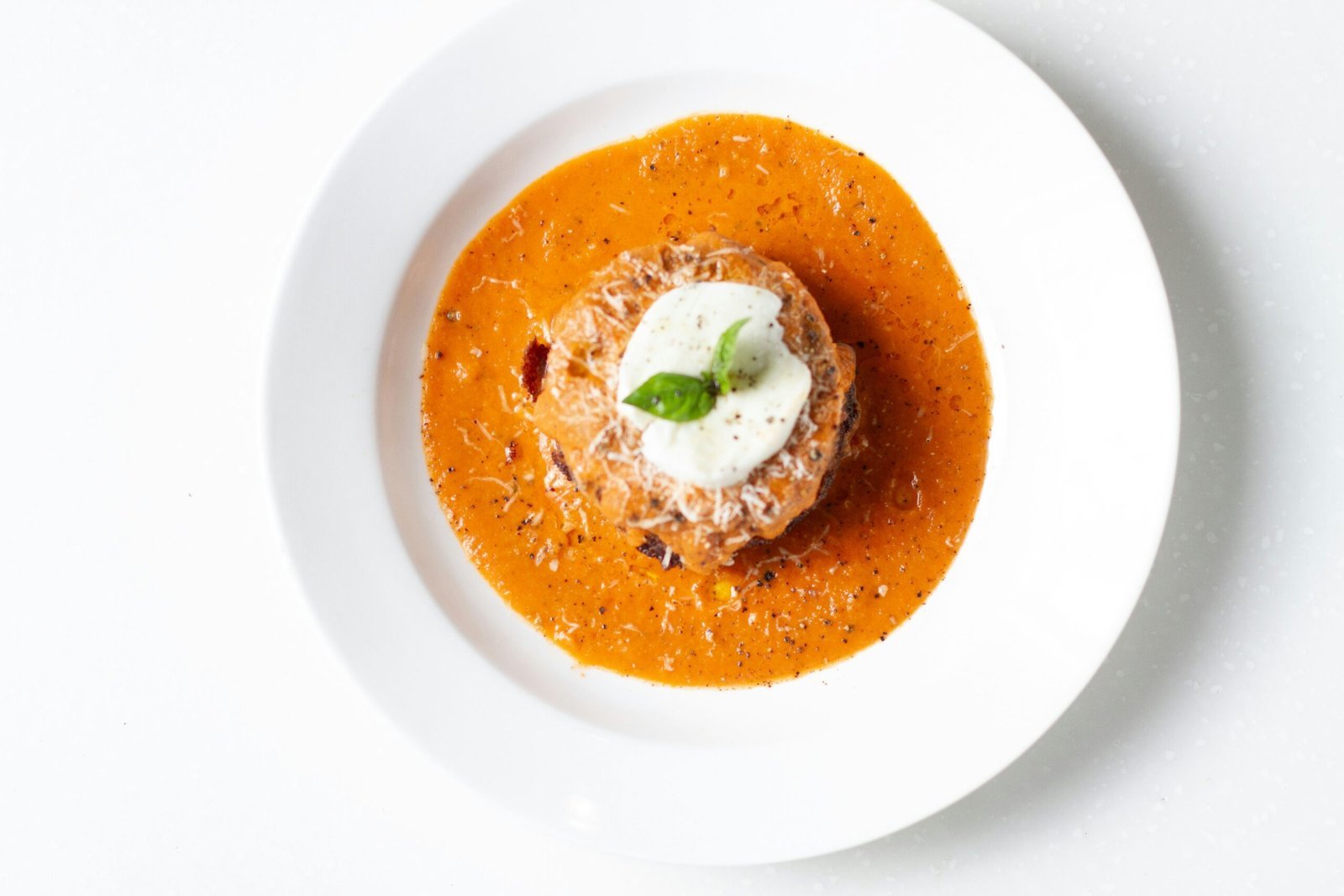 a white plate topped with a bowl of soup