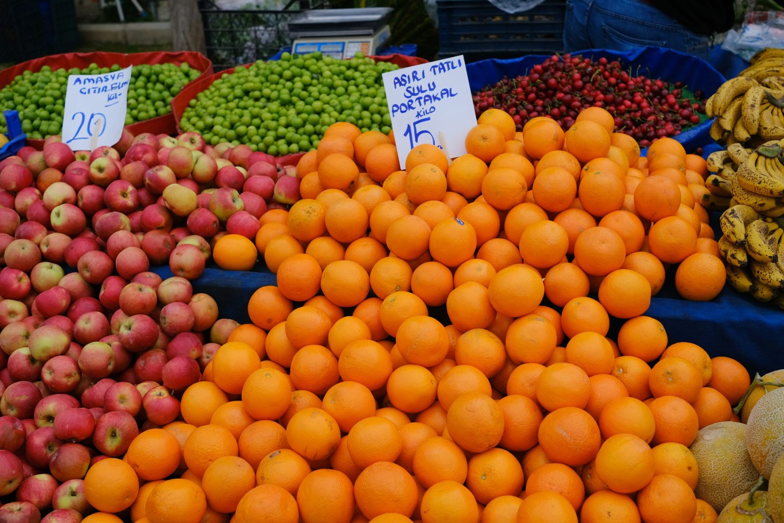 a fruit stand with oranges, apples, bananas and other fruits